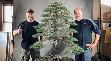 Michael and Zuma pose proudly by a meticulously wired Scots Pine.